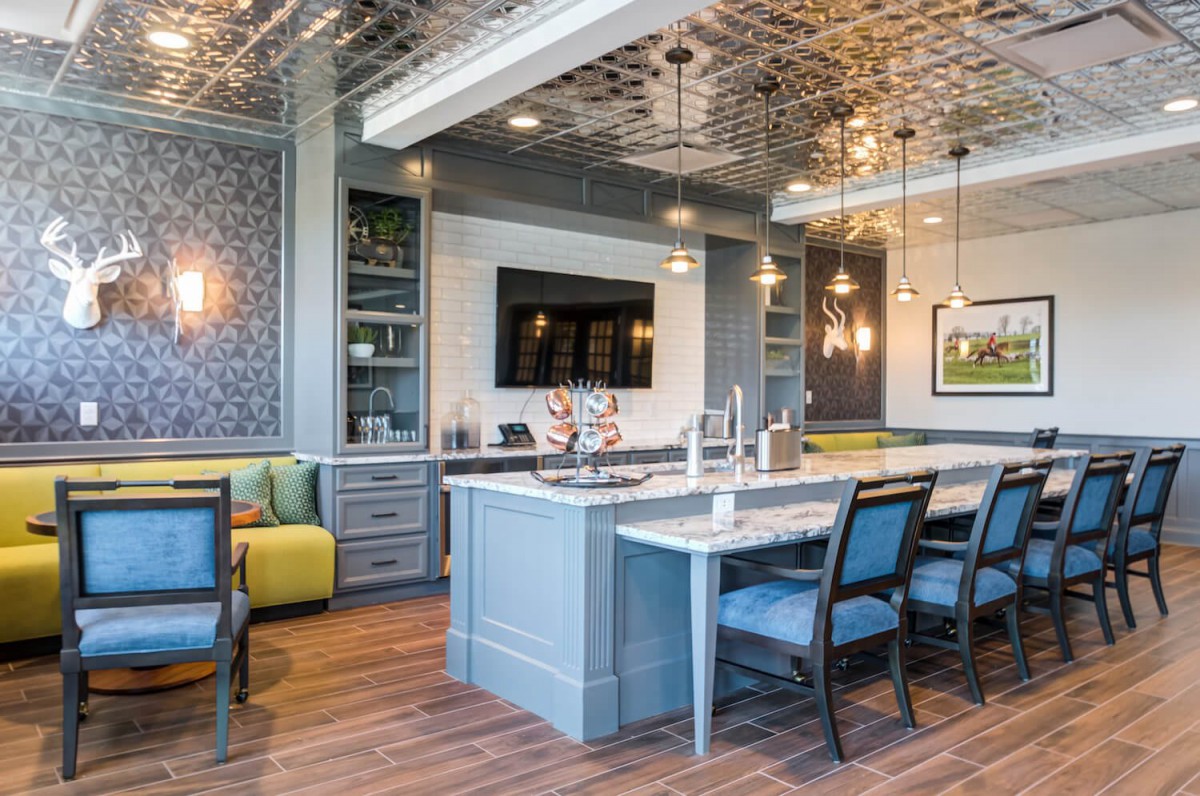 A modern kitchen and dining area with a stylish ceiling and island counter.