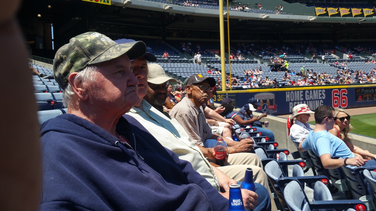 People seated in a stadium at a baseball game.