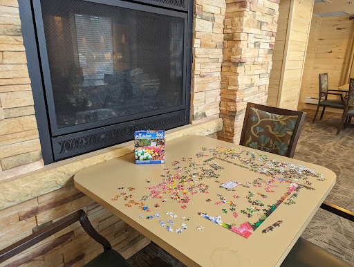 A cozy indoor setting featuring a partially completed puzzle on a table next to a fireplace.