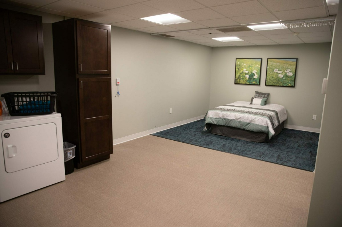 A minimalist bedroom with a single bed, wardrobe, and simple decor.