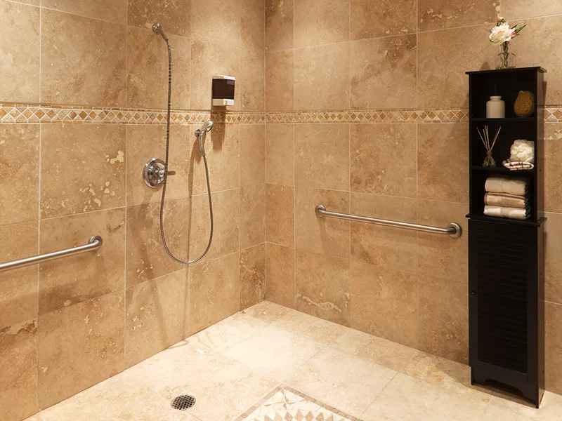 A modern walk-in shower with tiled walls and grab bars.