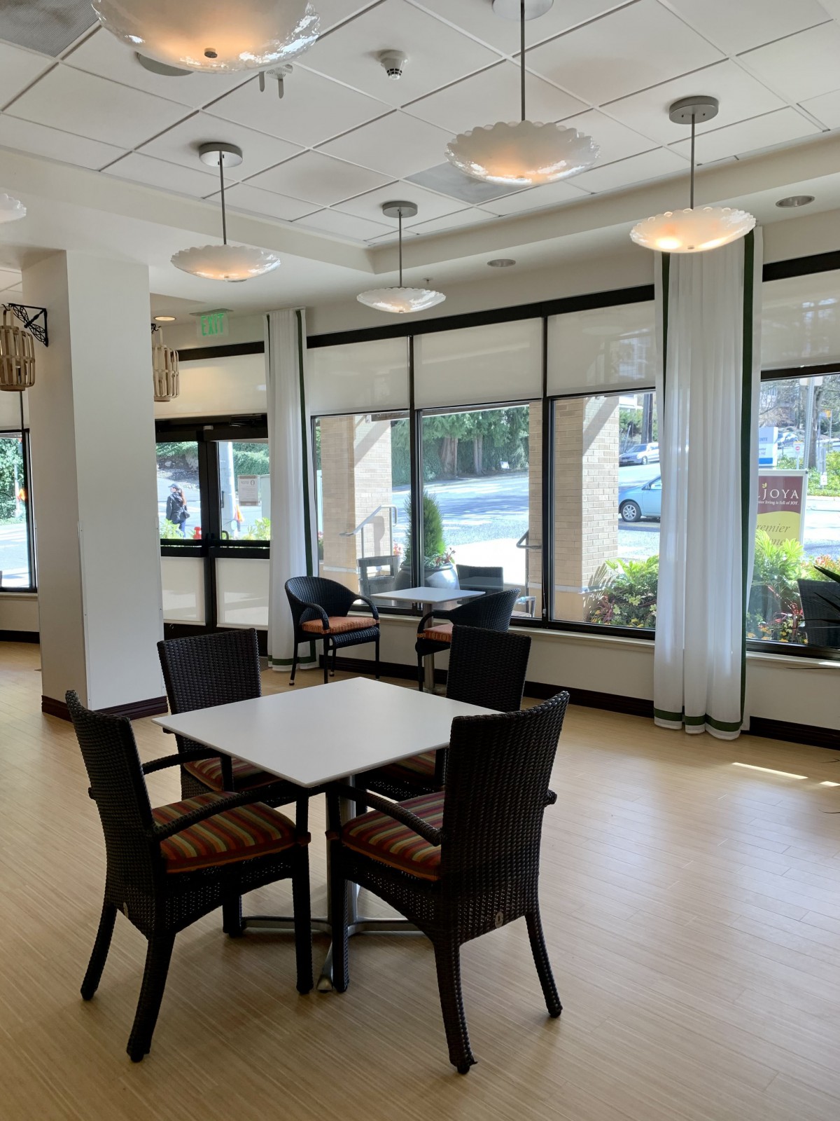 A bright and modern dining area with large windows and comfortable seating.