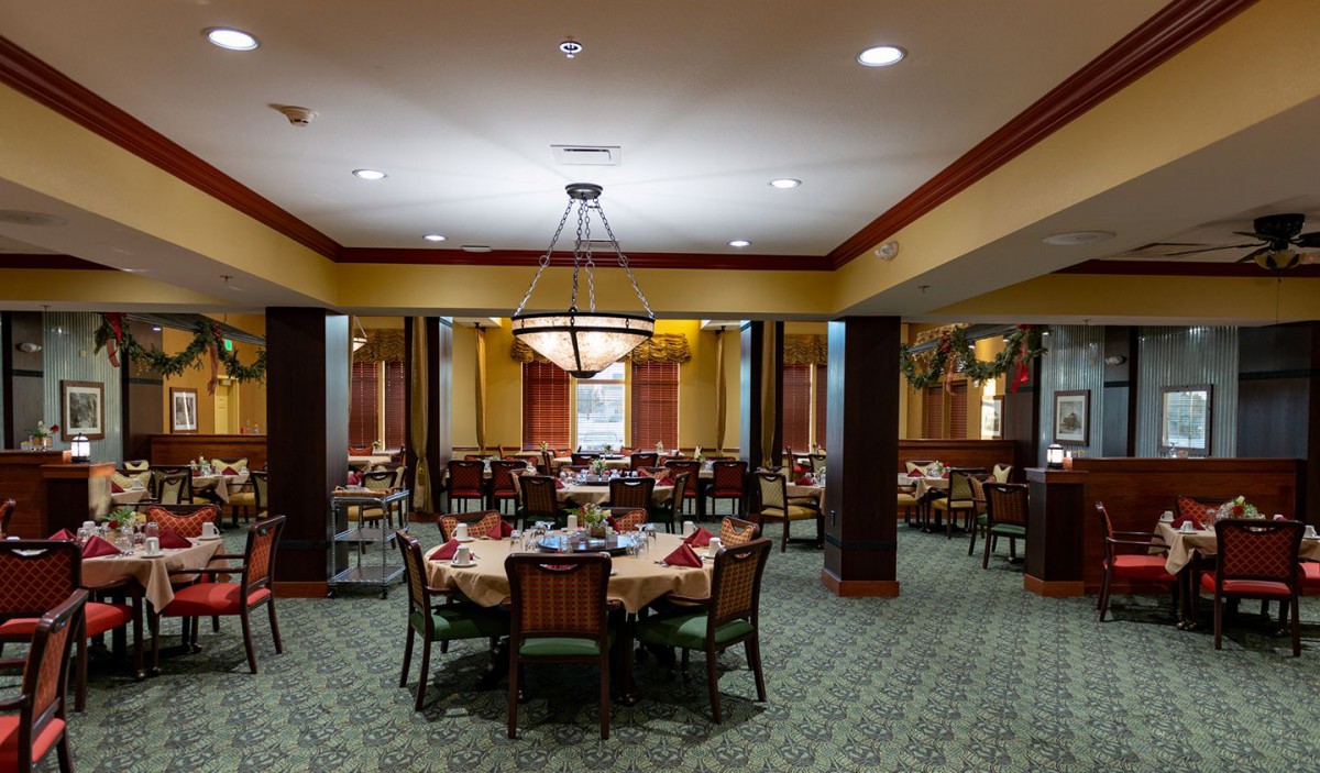 Elegant dining room with neatly arranged tables and chandelier lighting.
