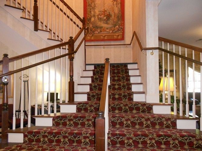 A traditional staircase with a patterned carpet and wooden banisters.