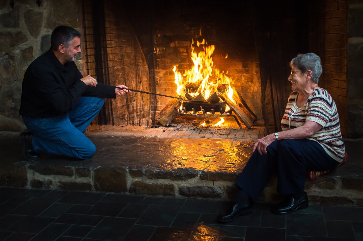 Two people enjoying a cozy evening by the fireplace.