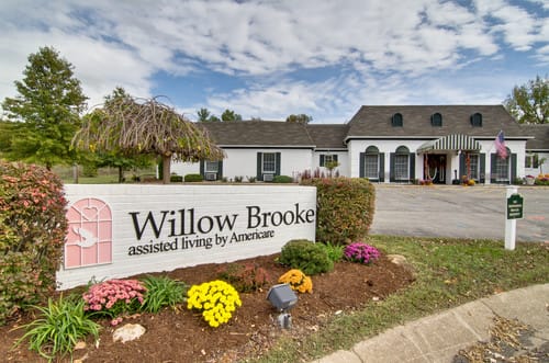 The exterior of Willow Brooke Assisted Living with a welcoming sign and landscaped entrance.