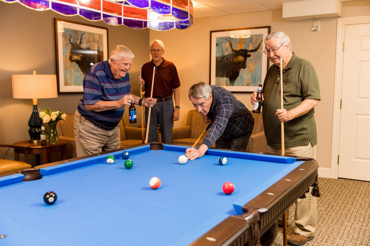 A group of men enjoying a game of billiards in an indoor setting.