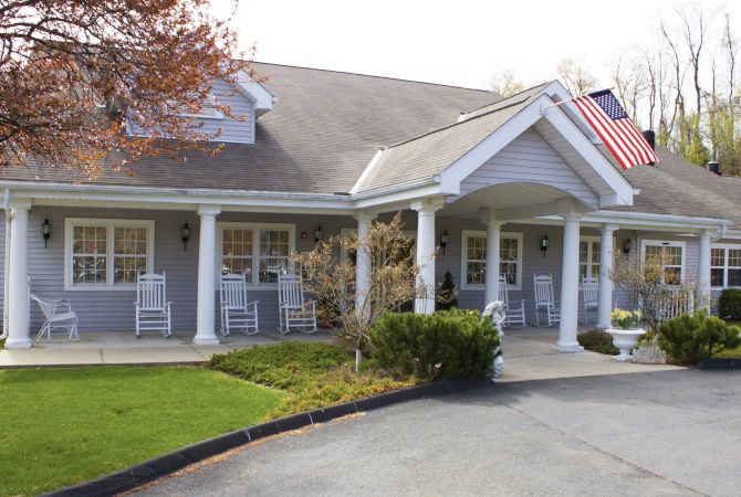 A suburban house with a front porch and American flag.