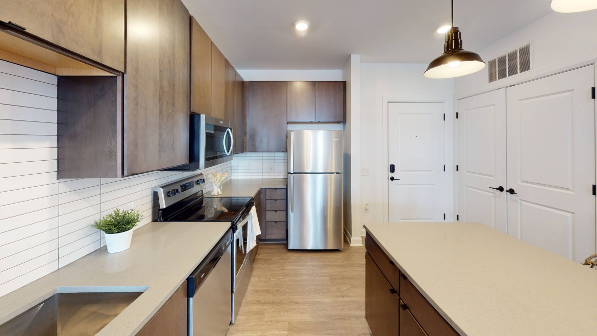 Modern kitchen with stainless steel appliances and wood cabinetry.
