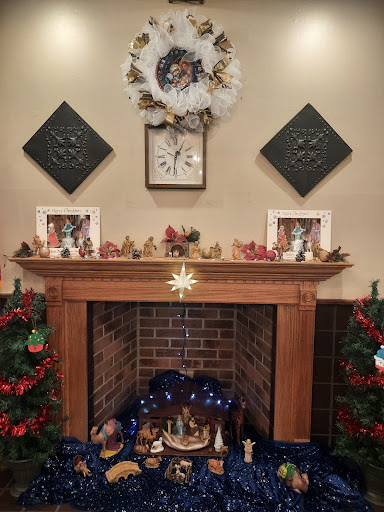 A beautifully decorated Christmas fireplace with a festive mantel featuring stockings, a wreath, and family photos.