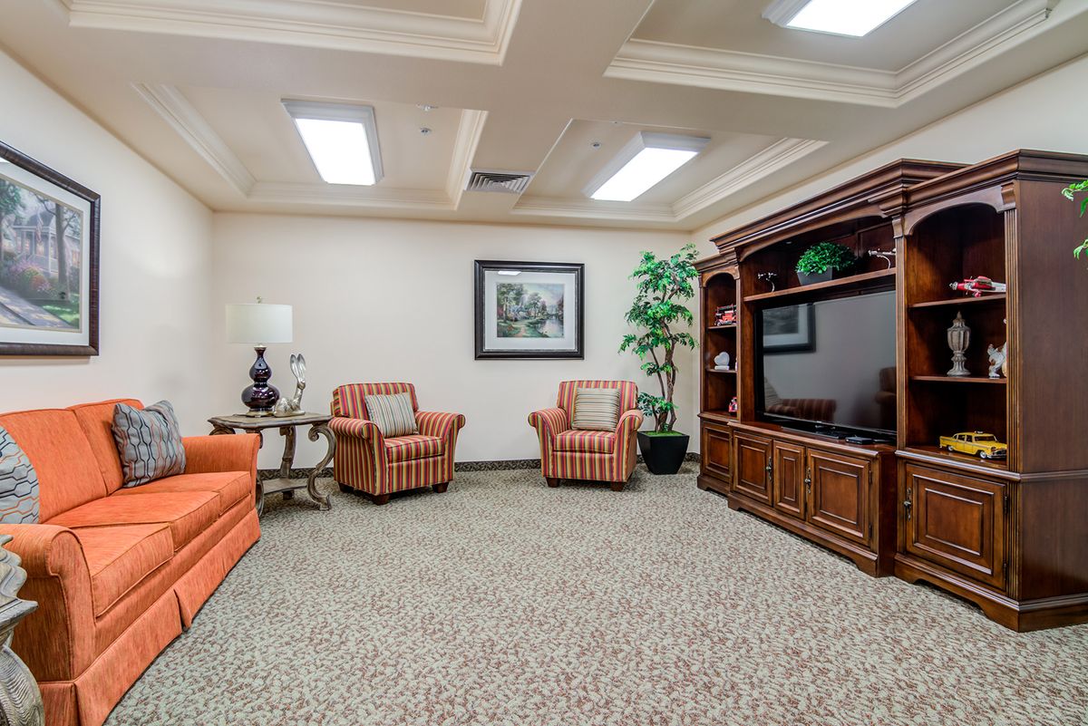 A cozy living room featuring comfortable seating, a large entertainment unit with a television, and tasteful decor.