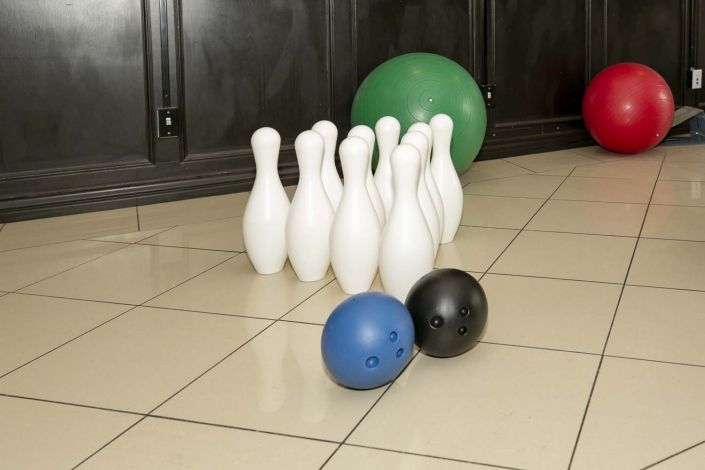 Indoor setup with bowling pins and balls ready for play.