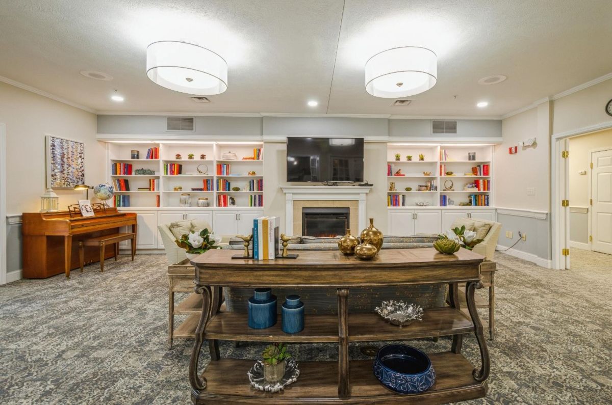 A cozy living room with elegant lighting, a central fireplace flanked by bookshelves, and stylish decor on the table.