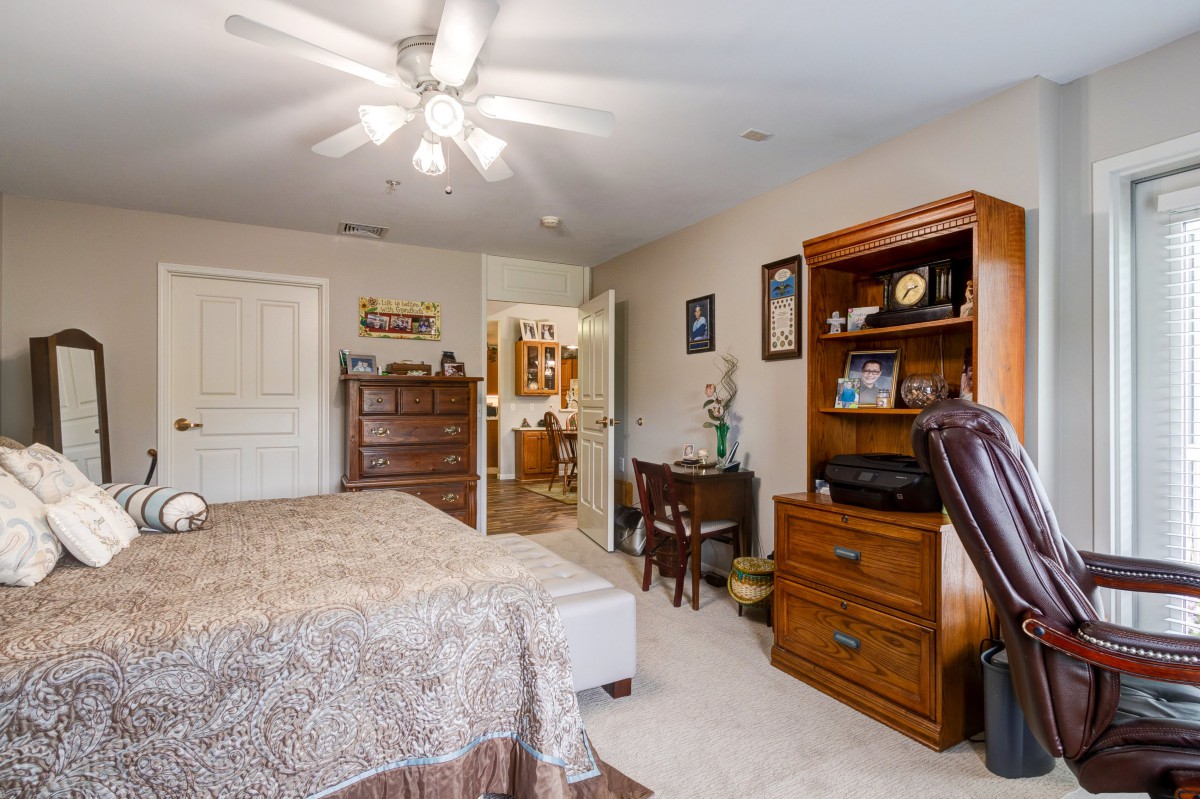 A cozy bedroom with wooden furniture and a ceiling fan.