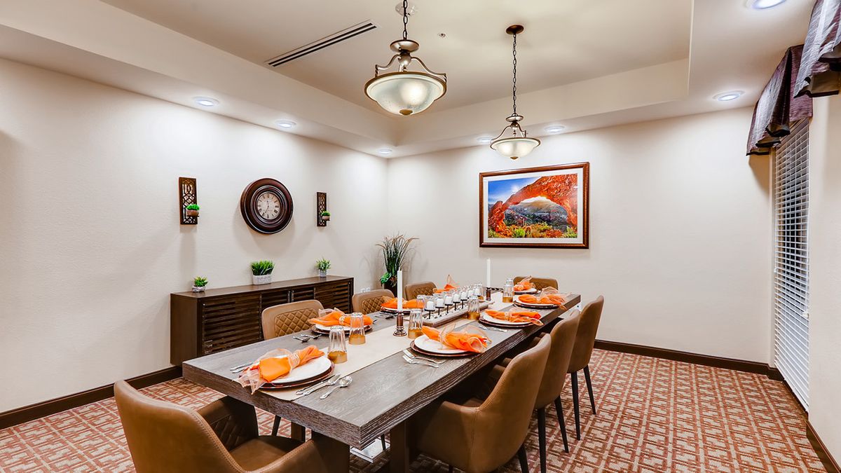 A beautifully decorated dining room with a set table, surrounded by stylish chairs and contemporary artwork on the walls.
