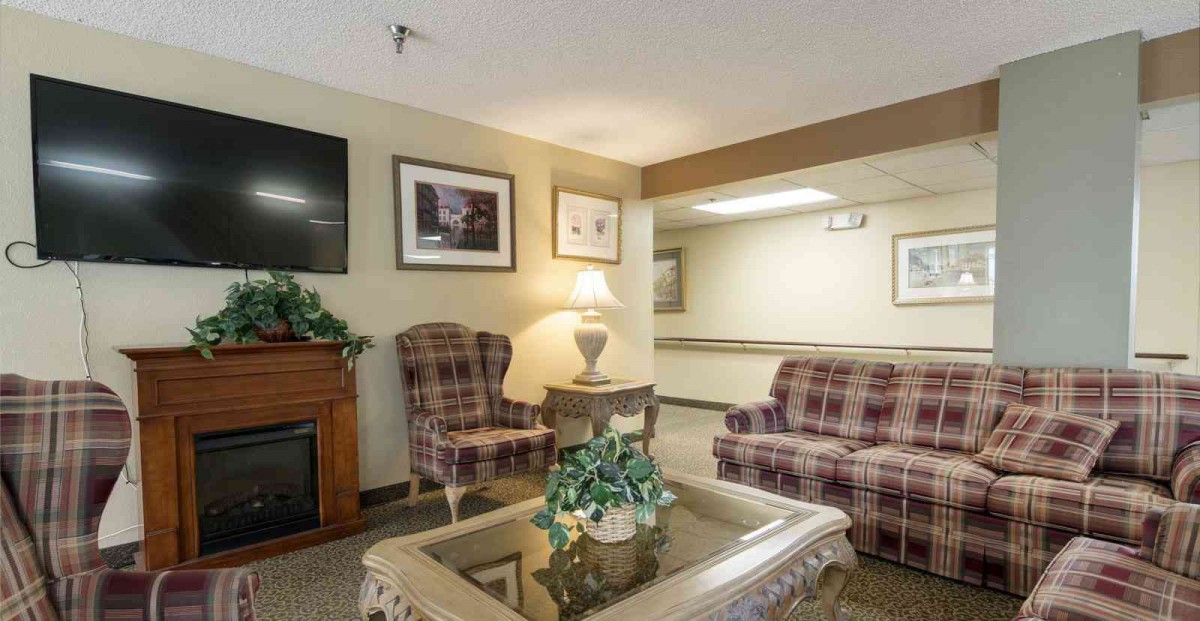 A cozy living room area with plaid armchairs, a wooden table, and decorative elements.