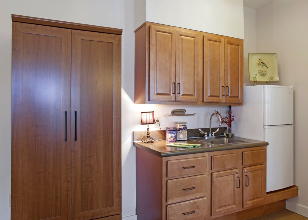 A modern kitchen interior with wooden cabinets and a sink.