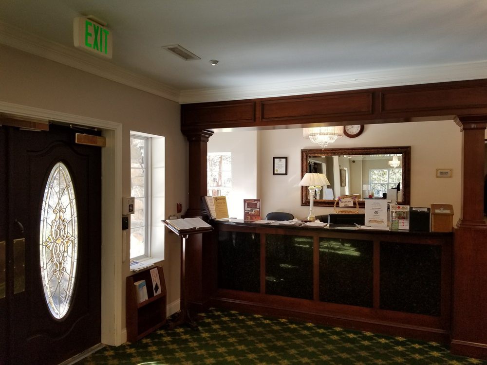 A hotel reception area with a front desk and decorative interior.