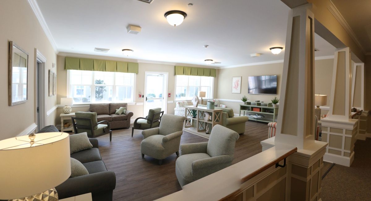 A spacious and well-lit living room with comfortable seating and a television.