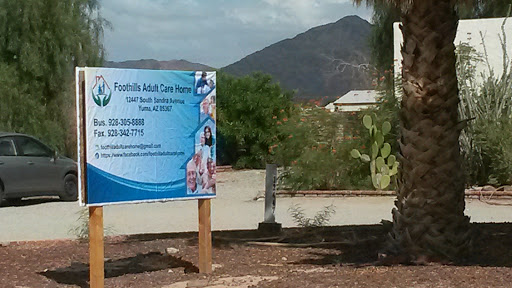 A sign for a residential adult care facility set against a backdrop of mountains.