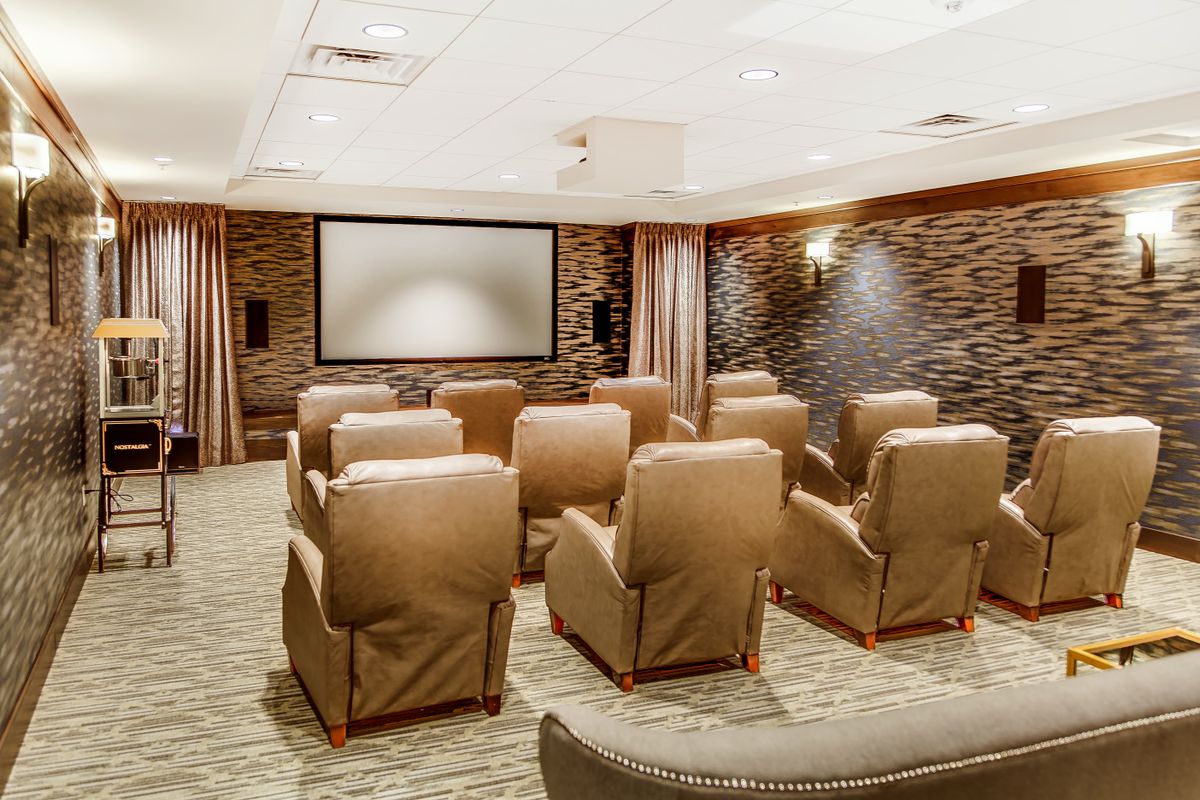 A luxurious home theater with comfortable seating and a large projector screen.