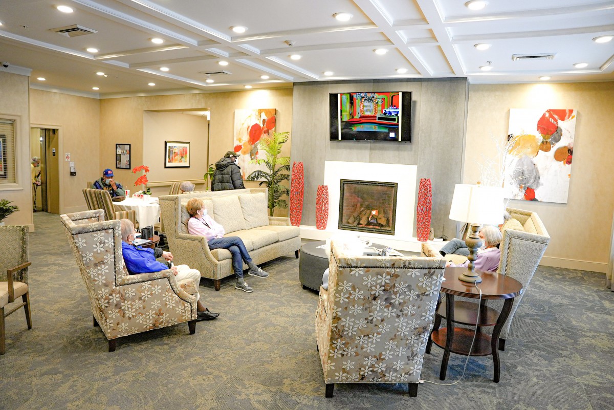 A cozy lounge area with comfortable seating, a fireplace, and a television.