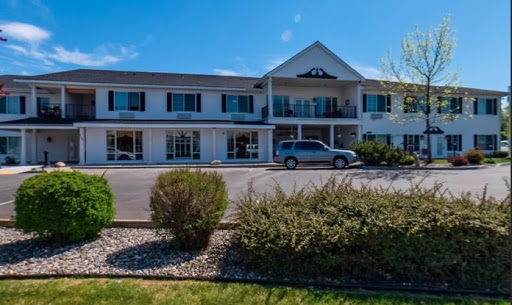 A sunny day at a charming motel with well-maintained landscaping.