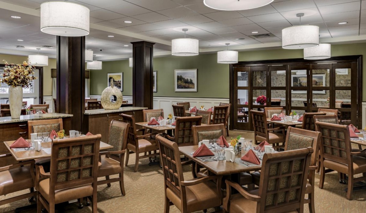 A cozy dining room with neatly arranged tables and chairs, adorned with decorative elements.