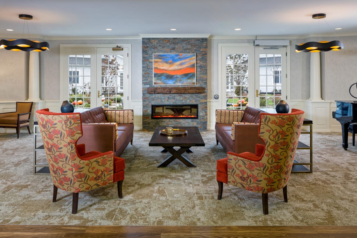 A modern living room with a fireplace, comfortable seating, and vibrant artwork.