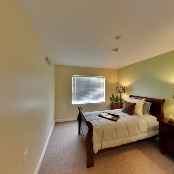 A cozy bedroom with a neatly made bed, bedside tables, and soft lighting.