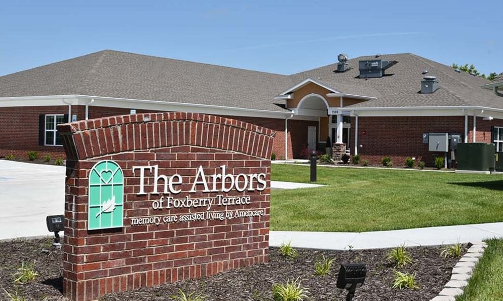 A retirement home facility with a brick exterior and a well-maintained lawn.