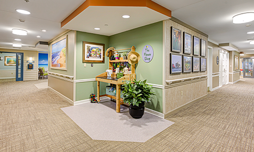 A well-decorated hallway with framed artwork and a small table with decorations.