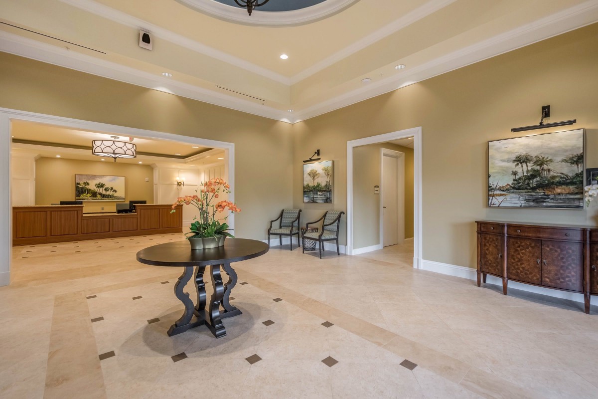 Elegant hotel lobby with a central table featuring flowers and seating area.