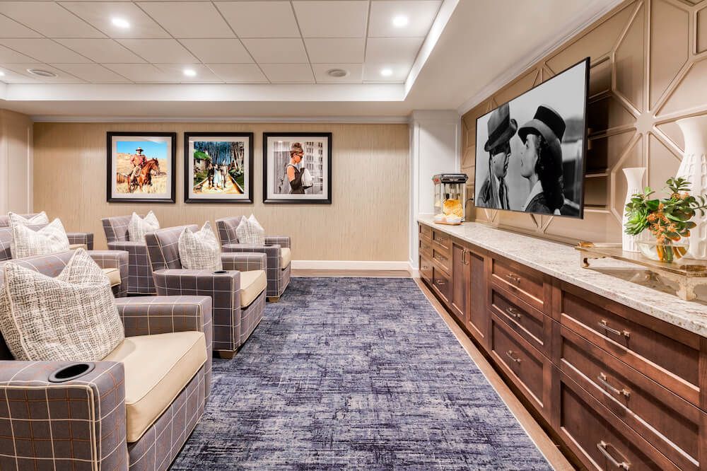 A cozy home theater room with comfortable seating and a large screen displaying a film.