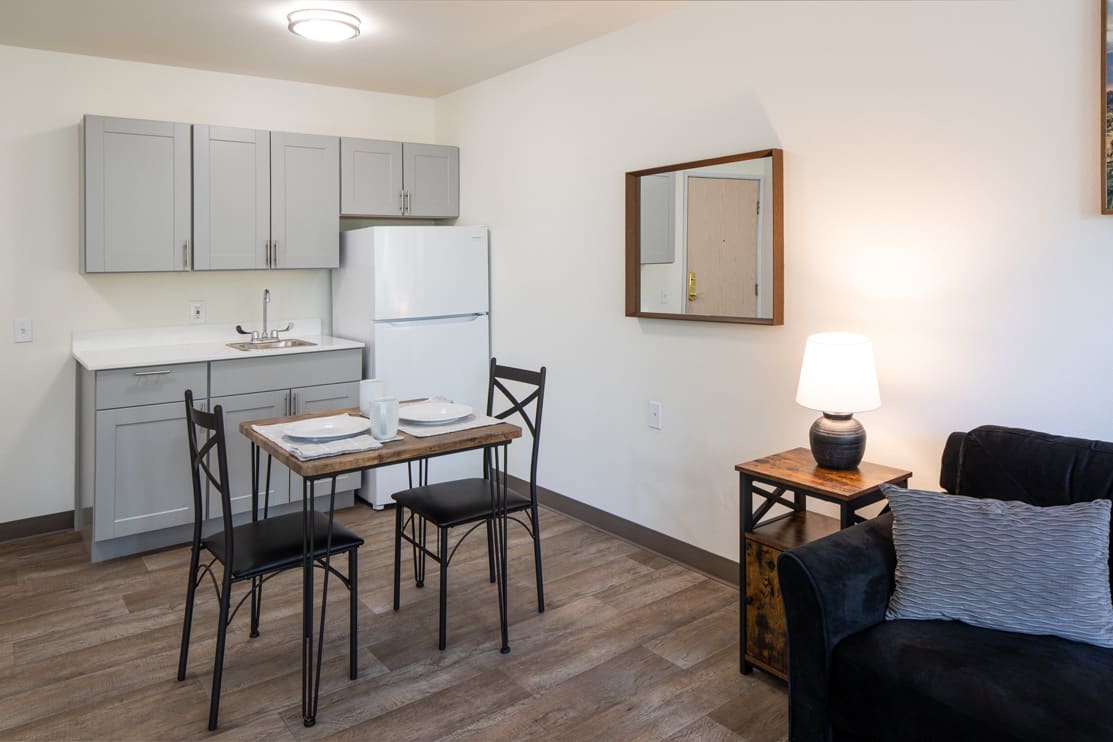 A cozy apartment kitchen with a small dining area and modern furnishings.