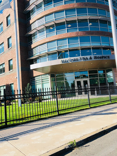 A modern office building featuring a glass facade and well-maintained landscaping.