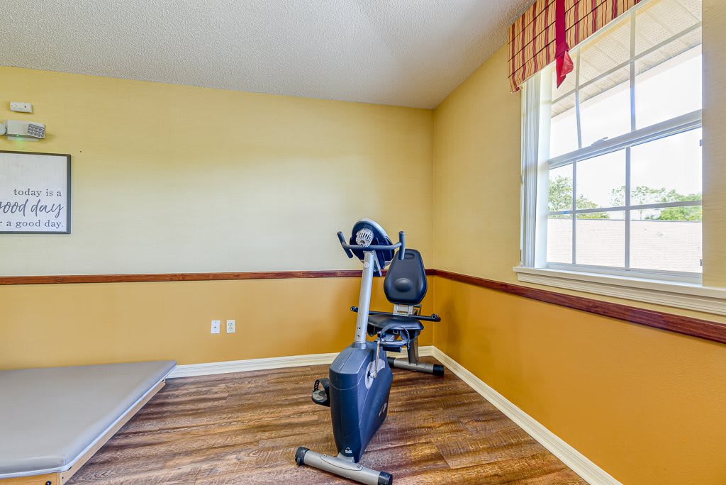 A small home gym with an exercise bike and a window letting in natural light.