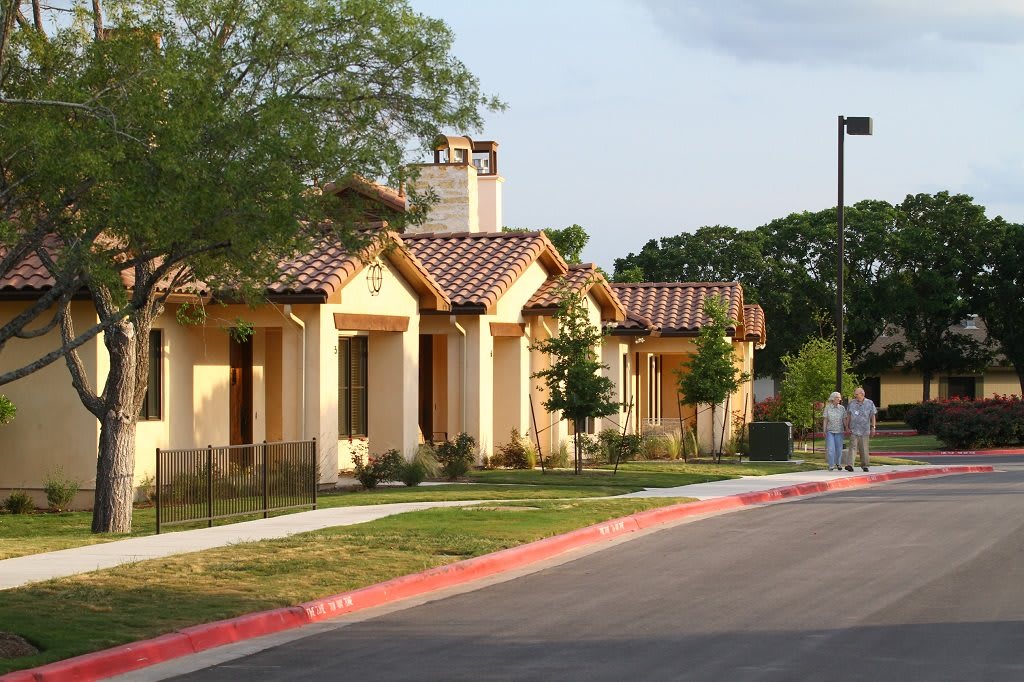 A row of suburban residential buildings with a tree-lined street.