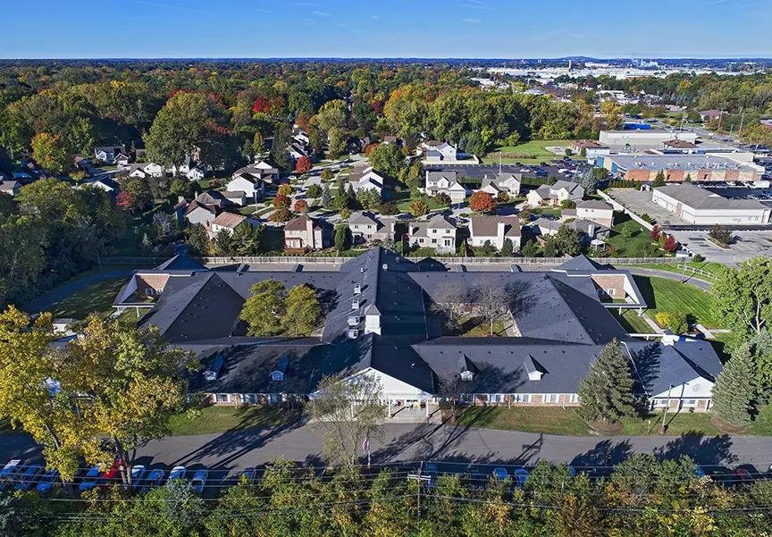An aerial view of a residential neighborhood surrounded by trees in autumn.