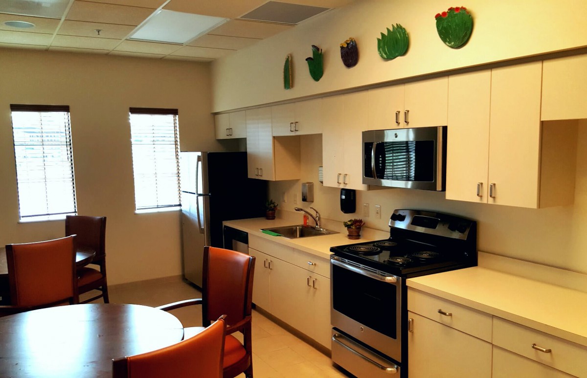 A modern kitchen with stainless steel appliances and decorative elements on top of the cabinets.