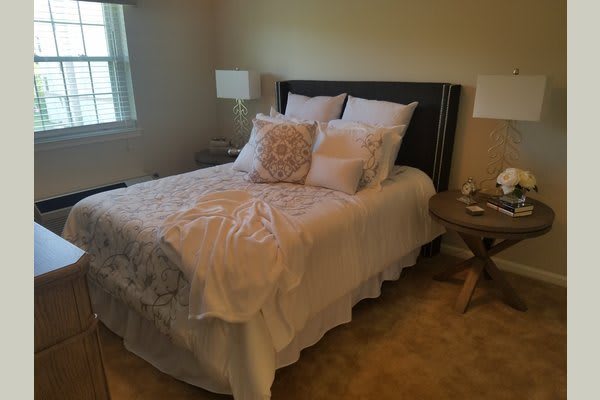 Cozy bedroom with a neatly made bed and decorative pillows.