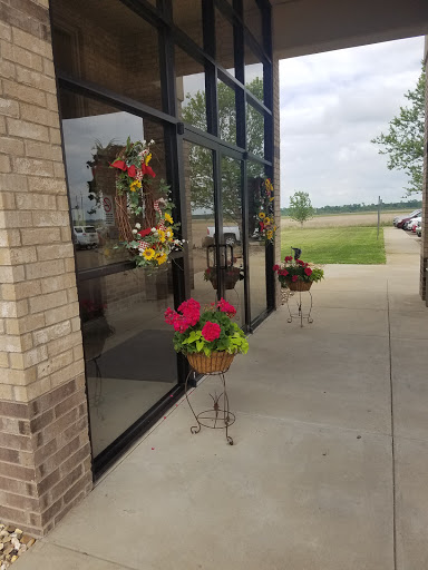 A vibrant display of flowers in planters at the entrance of a building.