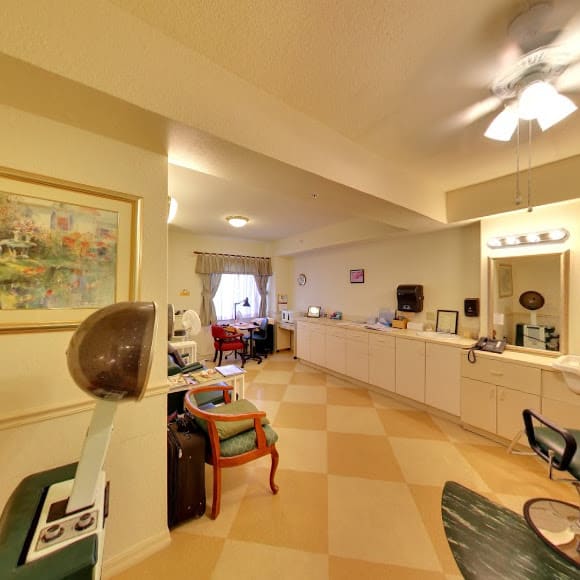 A cozy salon interior with a hairdryer, mirrors, and comfortable seating.