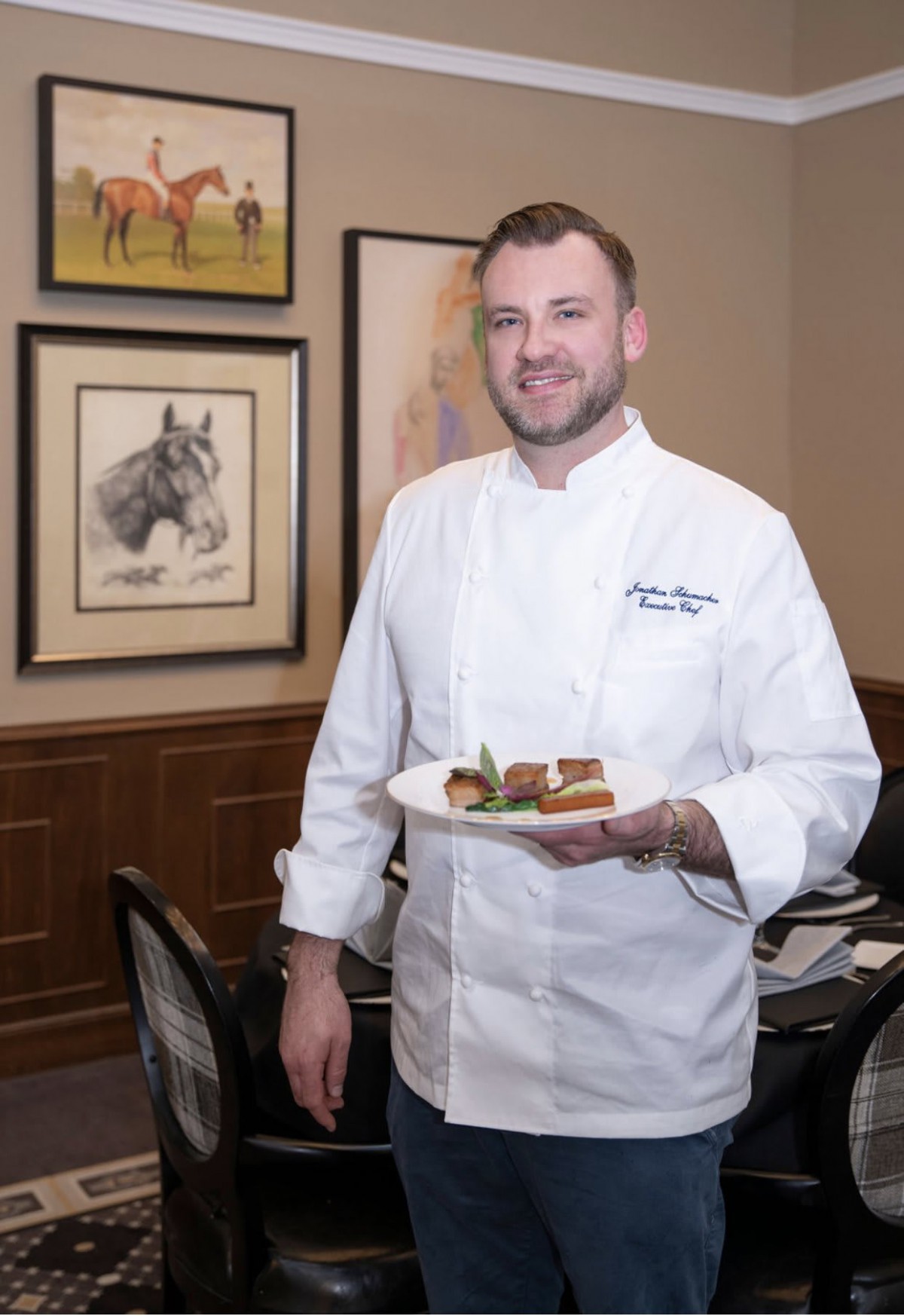 A chef presenting a dish in a restaurant setting.