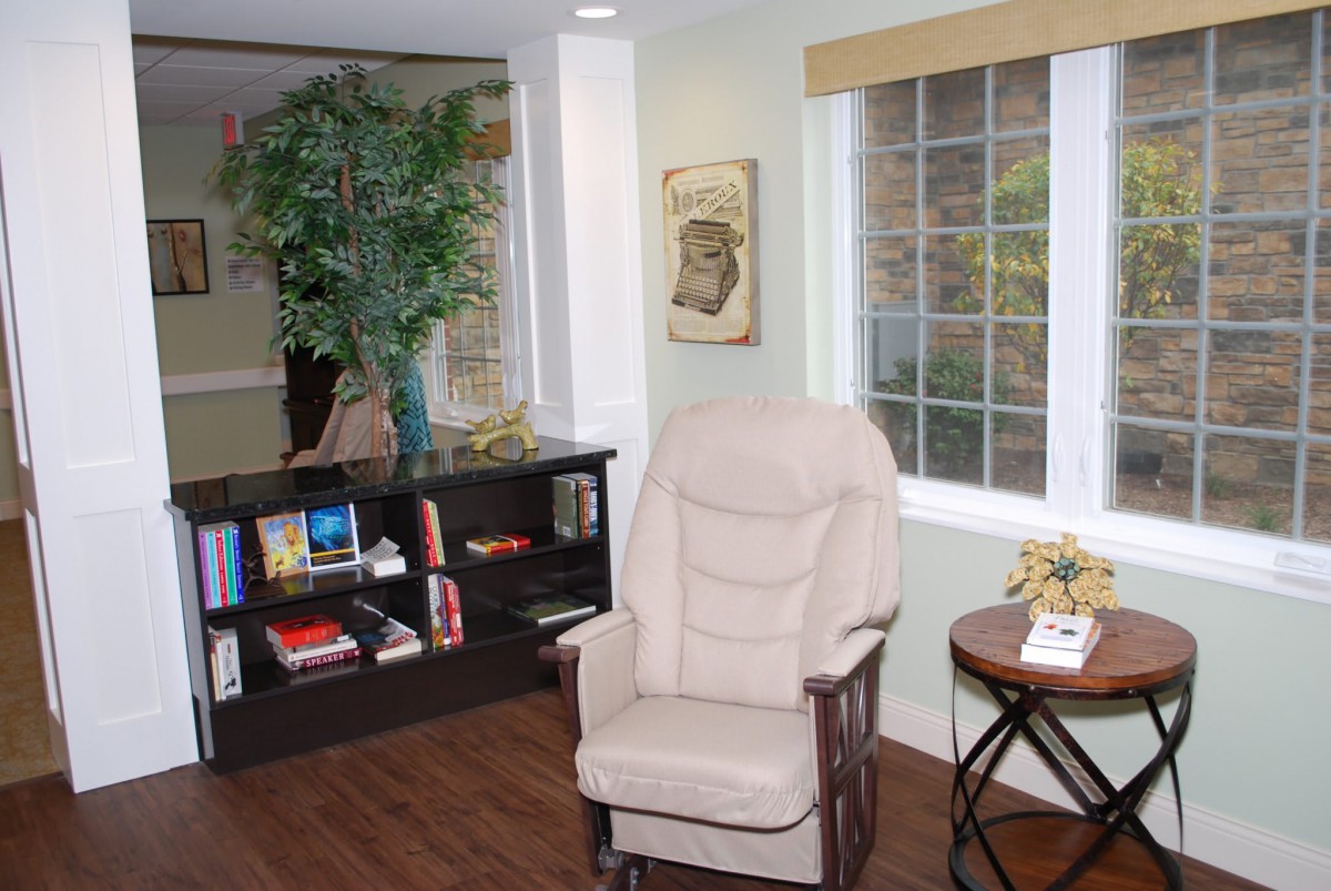 A cozy reading corner with an armchair and bookshelf.