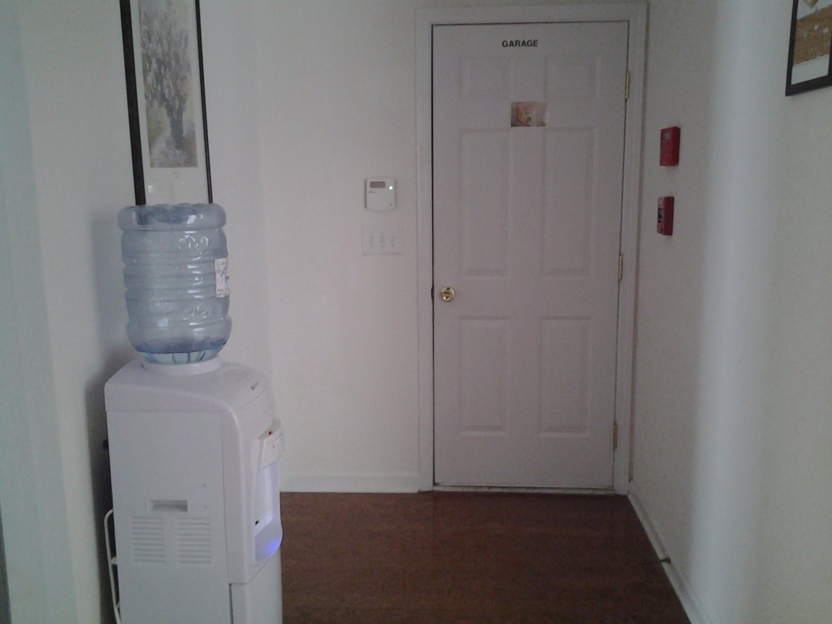 A hallway with a water cooler and a closed door.