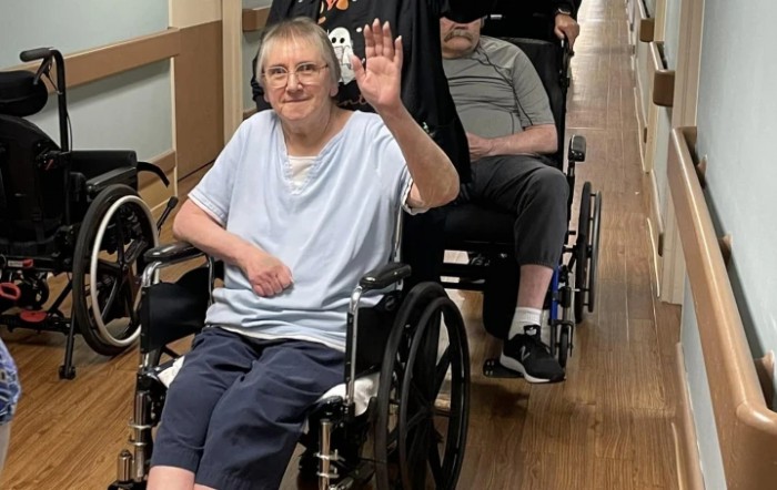 Elderly individuals in wheelchairs enjoying their time indoors.