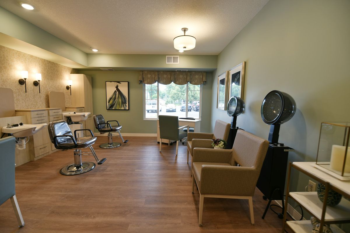 A well-lit salon interior with chairs, mirrors, and hairdryers.