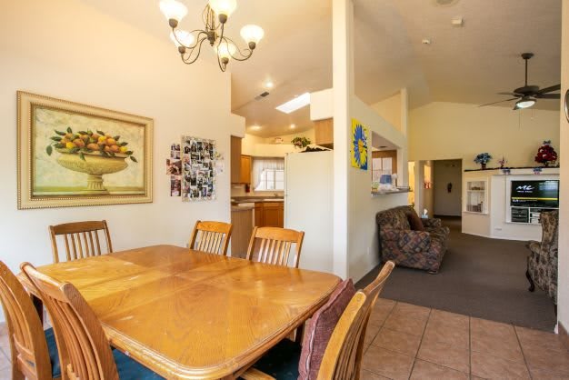 A cozy dining area with wooden furniture, adjacent to a kitchen and living space.