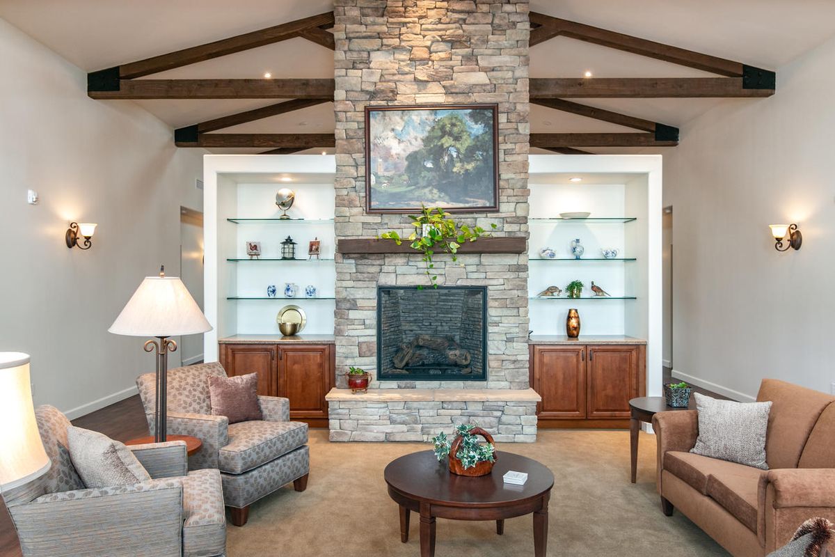 A cozy living room featuring a stone fireplace, comfortable seating, and elegant decor.